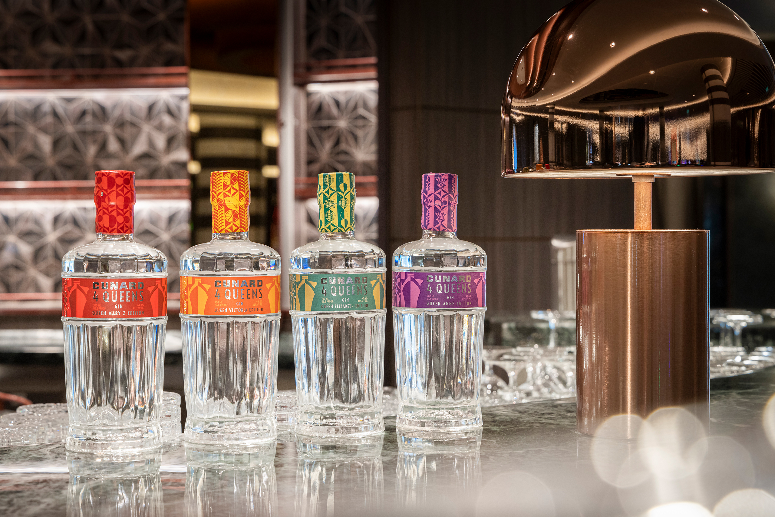 Four Cunard 4 Queens gin bottles lined up along a bar top
