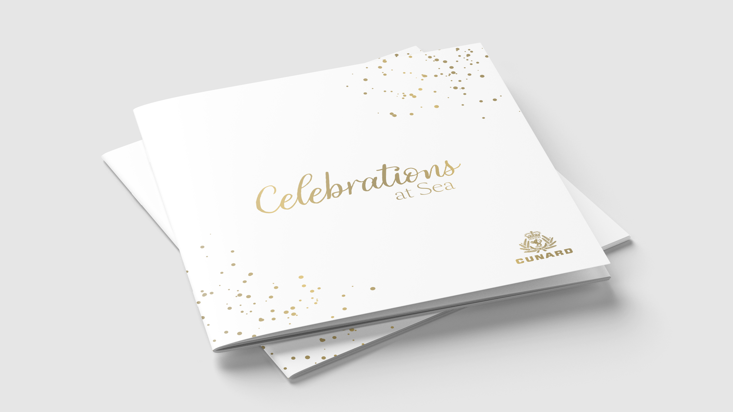 Celebrations at Sea brochures stacked, gold foil lettering on a white cover